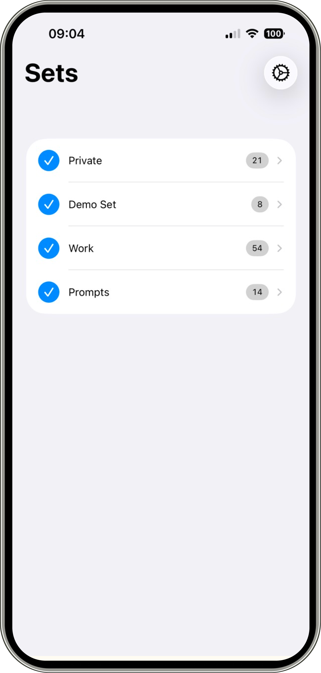 Screenshot of the Typinator iOS app showing the ‘Sets’ screen. The interface lists abbreviation sets including ‘Private,’ ‘Demo Set,’ ‘Work,’ and ‘Prompts,’ each with a checkmark indicating they are enabled and a number showing the count of entries. A settings icon appears in the top right, and the layout is clean and minimal.